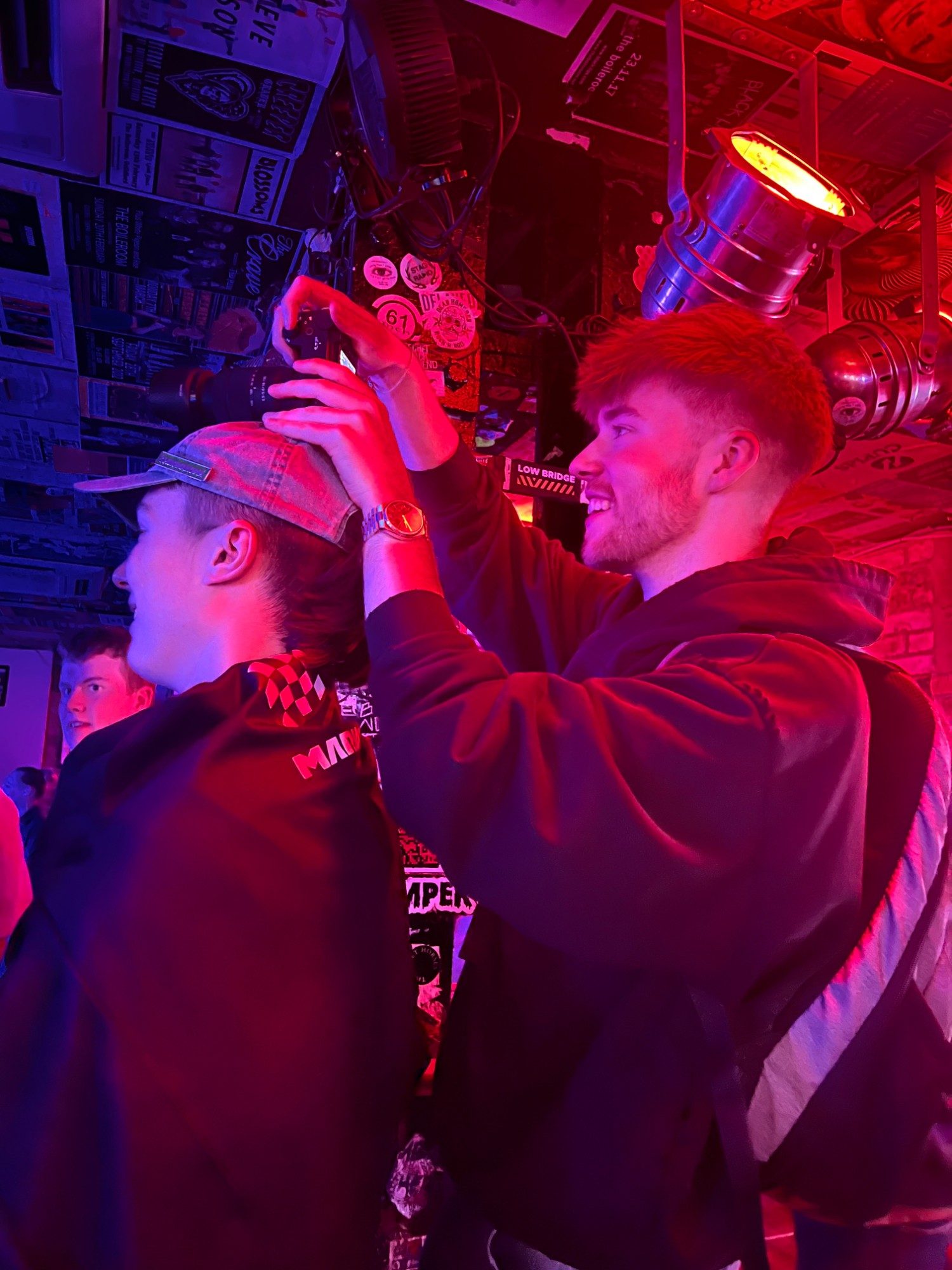 Behind the camera at a gig, under red stage lights